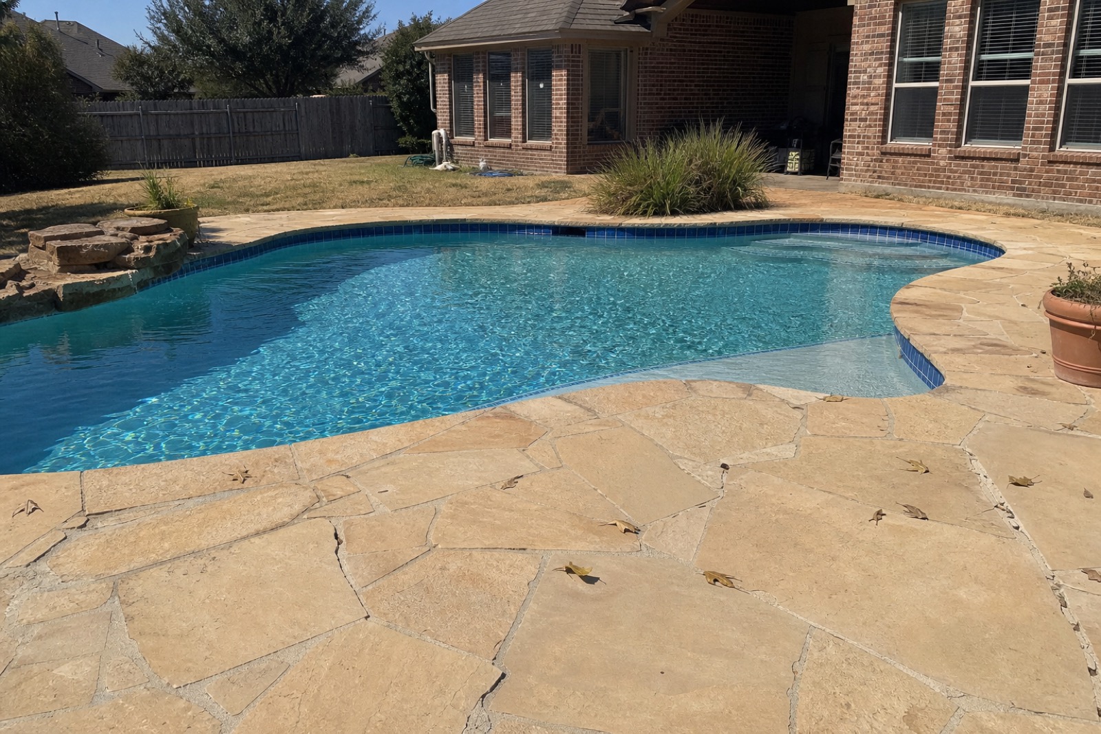 Residential flagstone-deck pool built and serviced by Sea Blue in a Fort Worth backyard